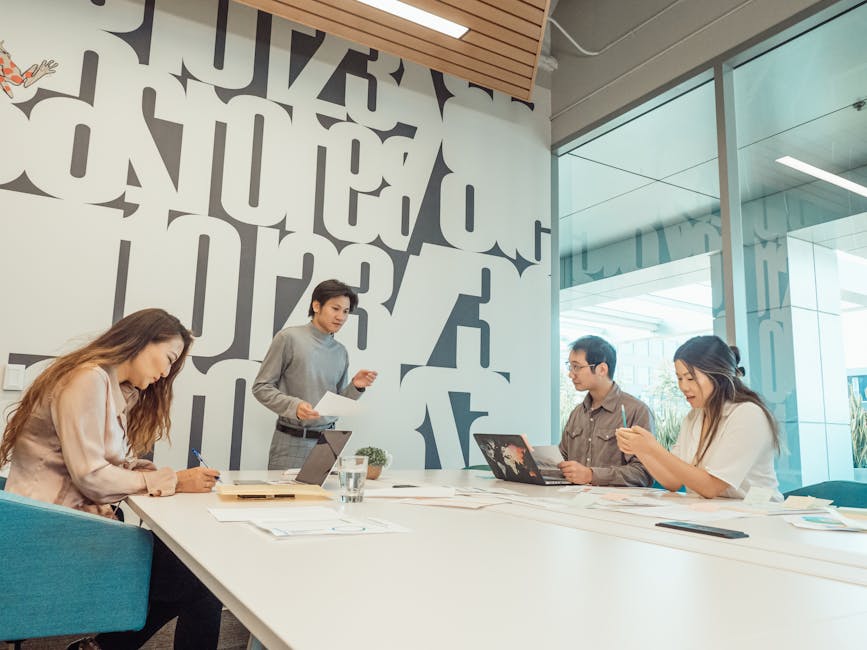 Group of colleagues engaged in a brainstorming session in a contemporary office with abstract design.