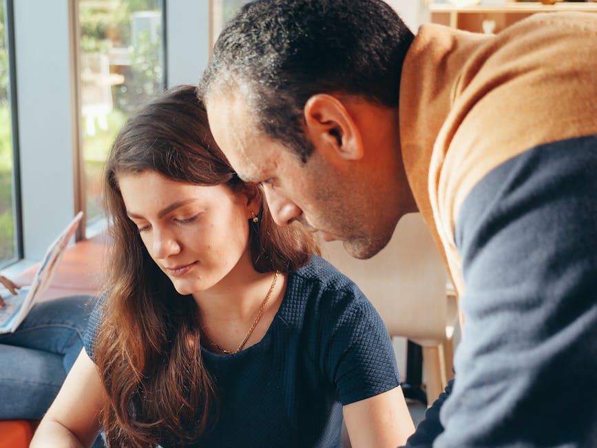 Two professionals engaged in a collaborative business discussion inside a well-lit office.