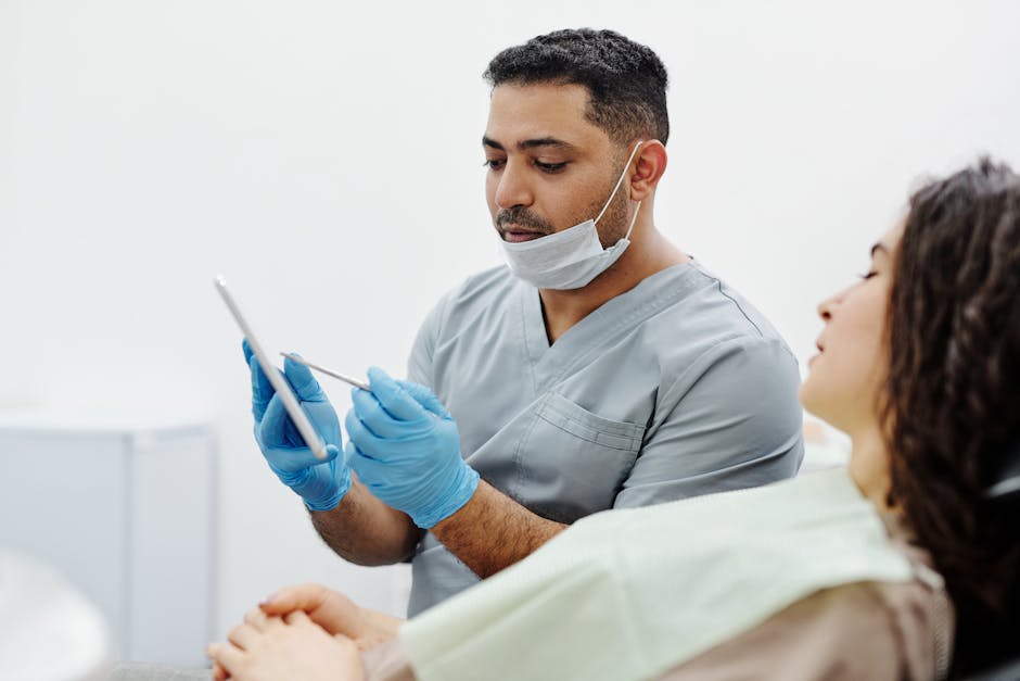A healthcare professional uses a tablet to consult with a patient in a clinical setting.