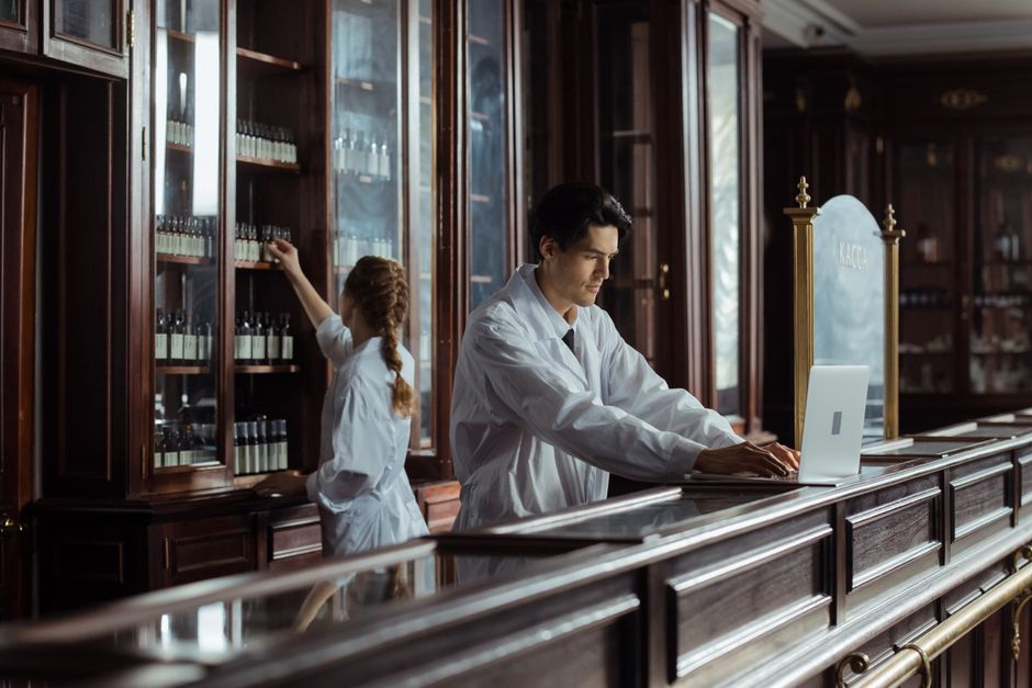 Pharmacists in a vintage pharmacy setting organizing and managing medications.